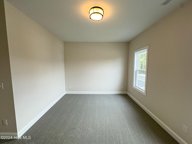 unfurnished bedroom featuring a closet and dark colored carpet