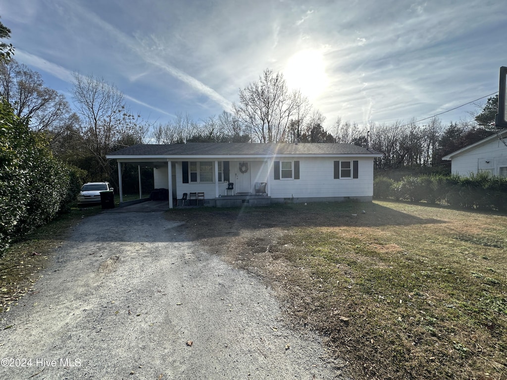 view of front of property with a front yard, a carport, and covered porch