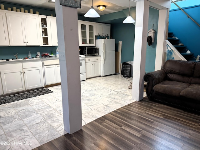 kitchen featuring white appliances, decorative light fixtures, white cabinetry, and light hardwood / wood-style flooring