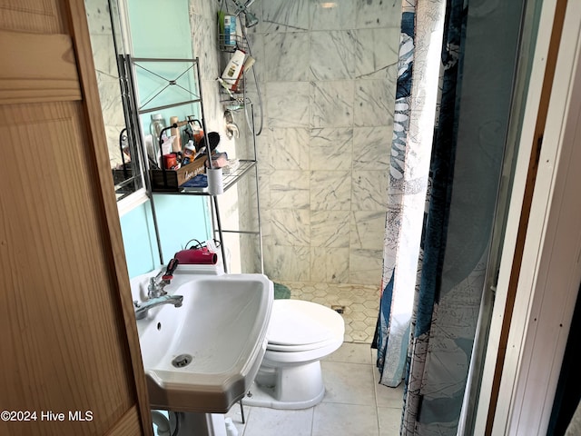 bathroom featuring toilet, tile patterned floors, walk in shower, and sink