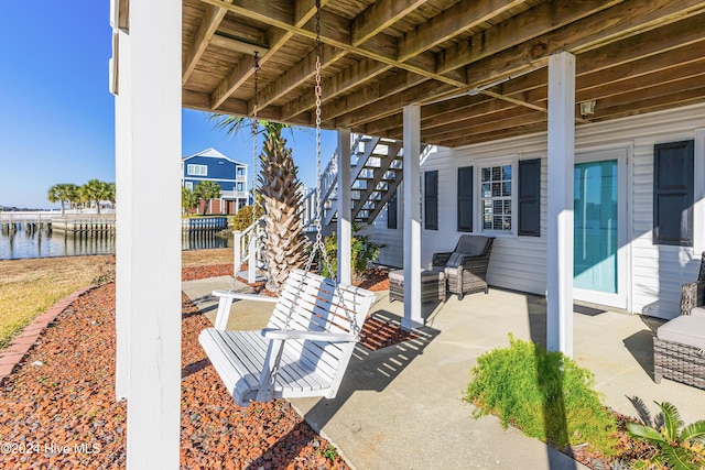 view of patio with stairs and a water view