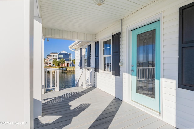 wooden deck featuring covered porch and a water view