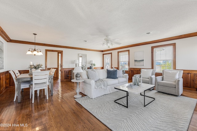 living room featuring ceiling fan with notable chandelier, dark hardwood / wood-style flooring, and a textured ceiling