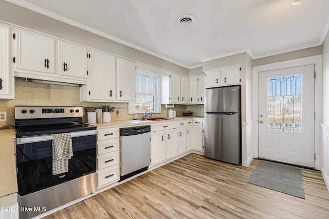 kitchen featuring white cabinets, appliances with stainless steel finishes, light wood-style floors, and visible vents