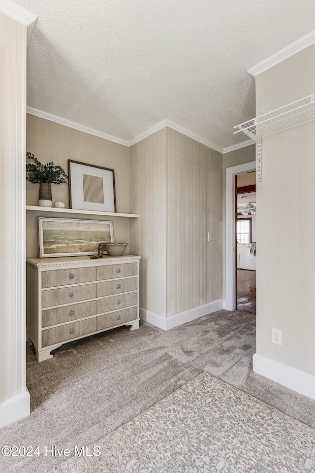 unfurnished bedroom with baseboards, ornamental molding, a textured ceiling, and carpet flooring