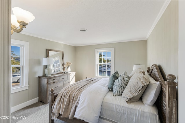 bedroom featuring light colored carpet, a textured ceiling, and ornamental molding