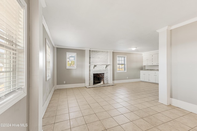 unfurnished living room with light tile patterned floors, baseboards, a brick fireplace, and ornamental molding