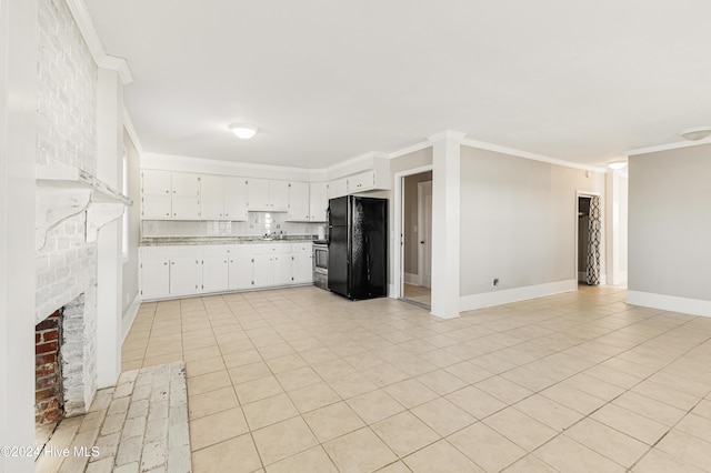 kitchen with light countertops, ornamental molding, freestanding refrigerator, white cabinetry, and baseboards