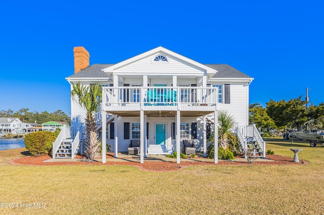 back of house featuring a lawn, a wooden deck, stairway, and a chimney