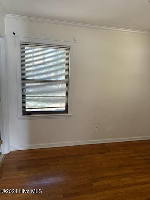 empty room featuring dark hardwood / wood-style flooring and crown molding