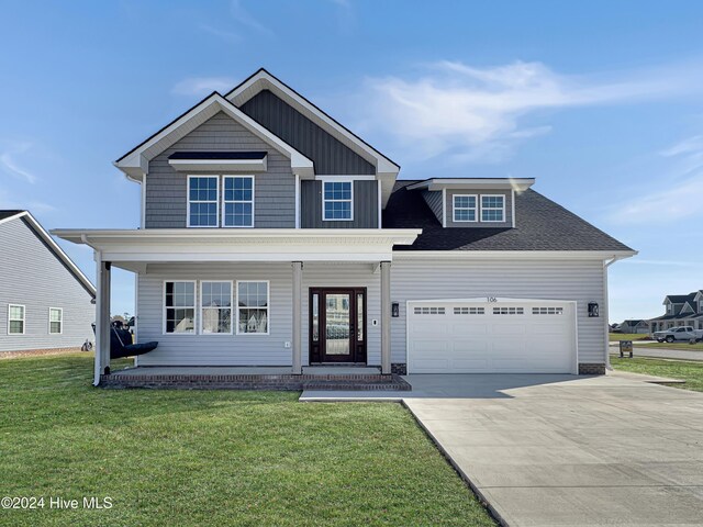 view of front of house featuring a front lawn, a porch, and a garage