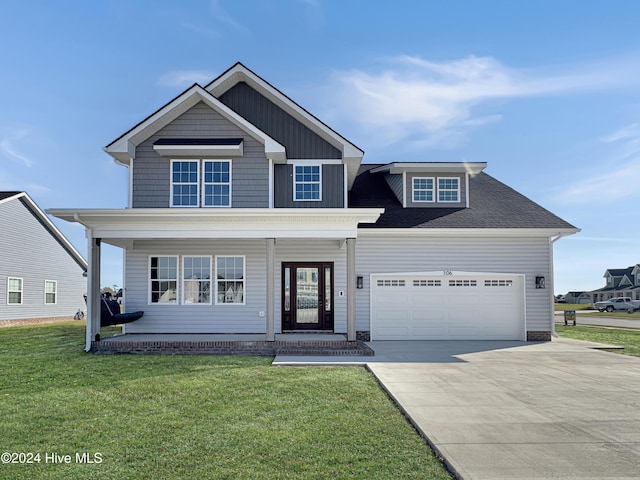 view of front of house featuring a garage, a front yard, and covered porch