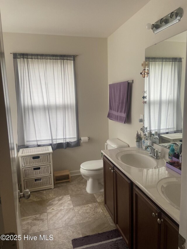 49 Patrick Henry Cir NW, Supply, NC 28462 - bathroom featuring healthy amount of natural light, double vanity, toilet, and baseboards