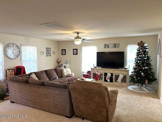 carpeted living room with ceiling fan