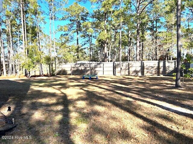 49 Patrick Henry Cir NW, Supply, NC 28462 - view of yard featuring fence and view of wooded area