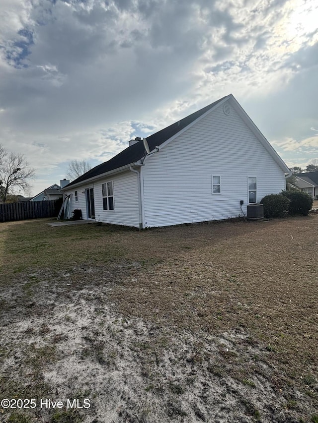 view of side of home featuring a yard and central AC unit