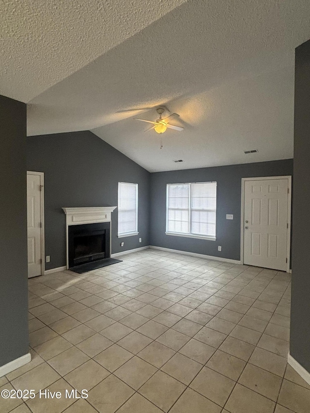 unfurnished living room featuring lofted ceiling, a textured ceiling, ceiling fan, and light tile patterned flooring