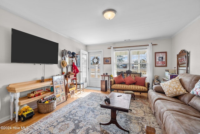 living room with crown molding and light hardwood / wood-style floors