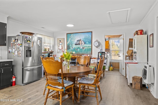 dining room with ornamental molding, heating unit, and light hardwood / wood-style floors