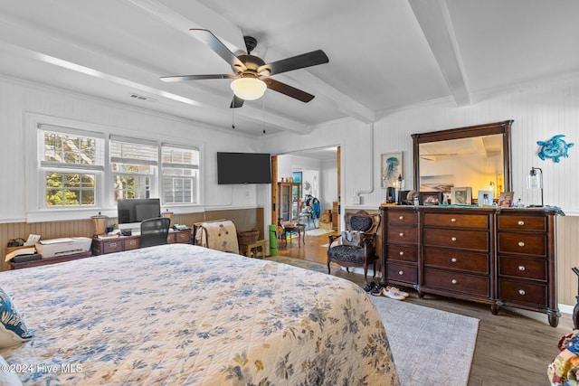 bedroom featuring hardwood / wood-style floors, ceiling fan, crown molding, and beam ceiling