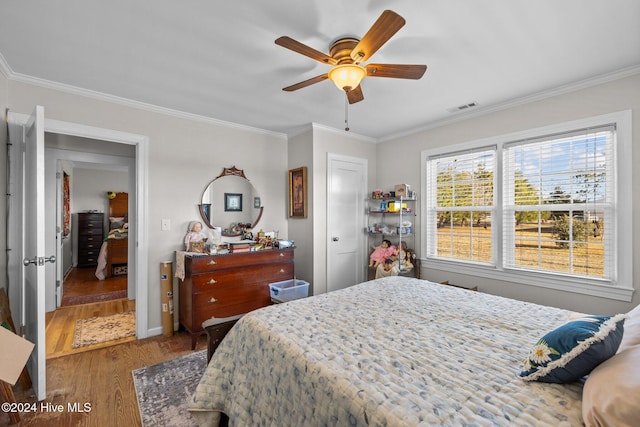 bedroom with hardwood / wood-style flooring, ceiling fan, and crown molding