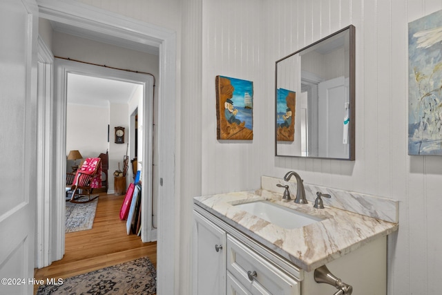 bathroom featuring wooden walls, vanity, and wood-type flooring