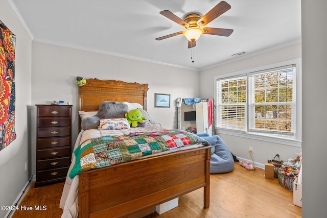 bedroom featuring hardwood / wood-style flooring, ceiling fan, and ornamental molding