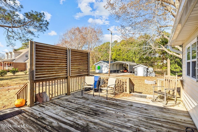 wooden deck featuring a carport and a shed