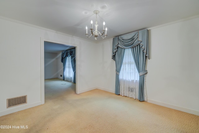 carpeted spare room with an inviting chandelier and ornamental molding