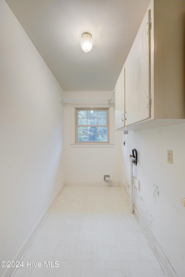 laundry area with hookup for an electric dryer and cabinets