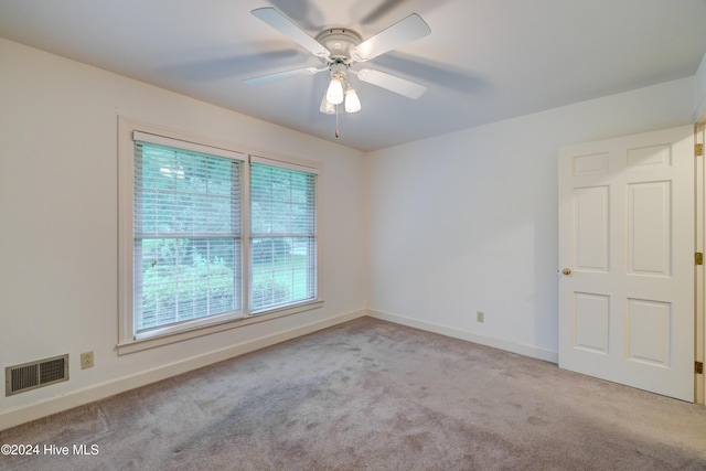 carpeted empty room featuring plenty of natural light and ceiling fan