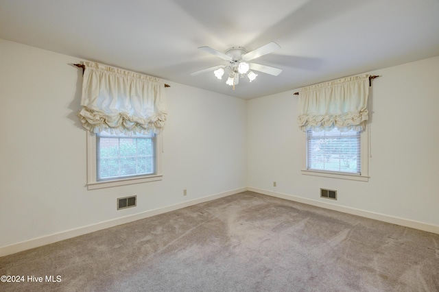 carpeted empty room featuring plenty of natural light and ceiling fan