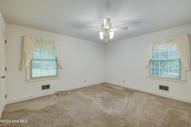 spare room featuring light carpet and ceiling fan