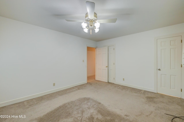 spare room with ceiling fan and carpet