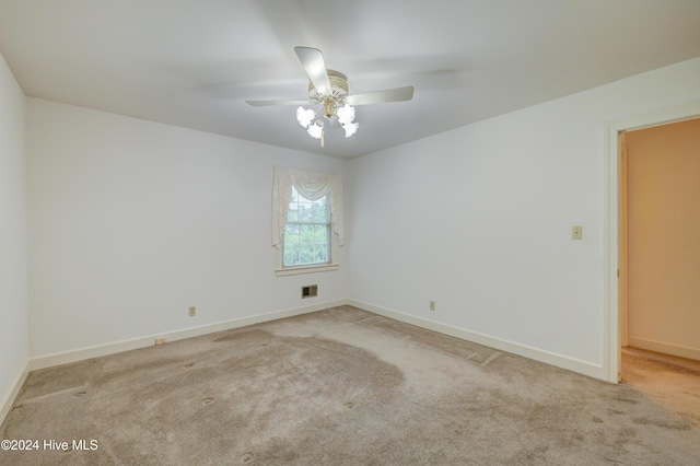 spare room featuring light carpet and ceiling fan