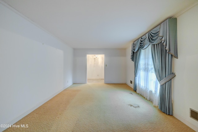 unfurnished room with light colored carpet and crown molding