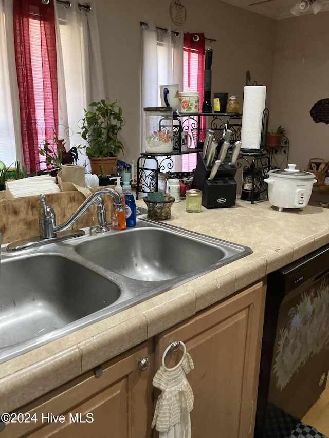 kitchen with dishwasher, sink, and light brown cabinetry