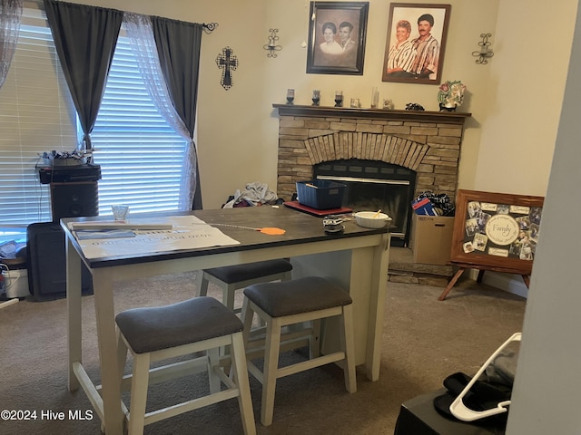 dining space with carpet flooring and a fireplace