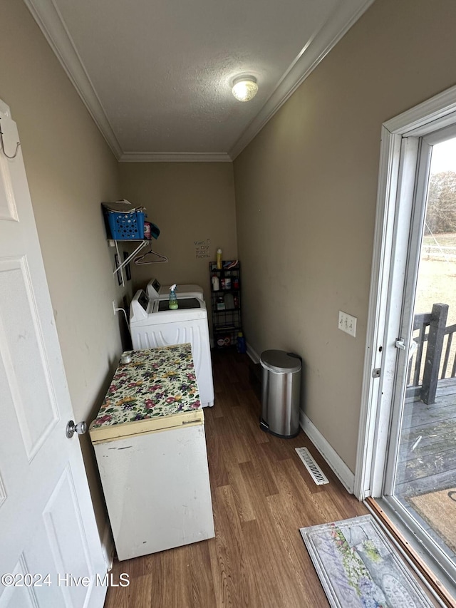 laundry area with hardwood / wood-style flooring, separate washer and dryer, crown molding, and a textured ceiling