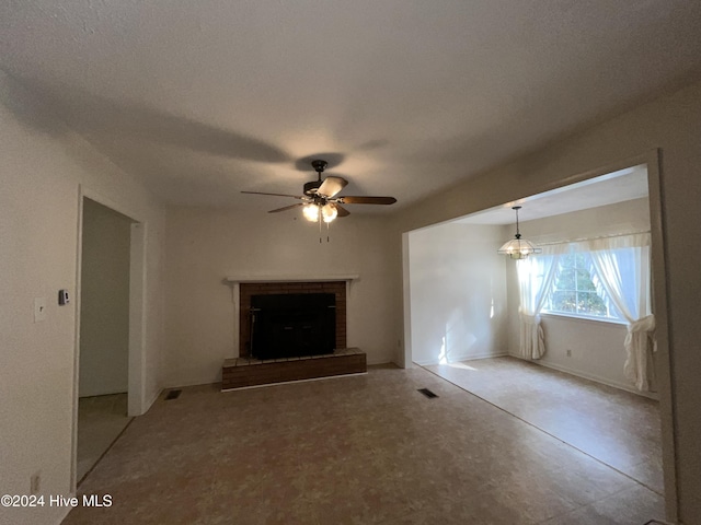 unfurnished living room featuring a textured ceiling, ceiling fan, and a fireplace