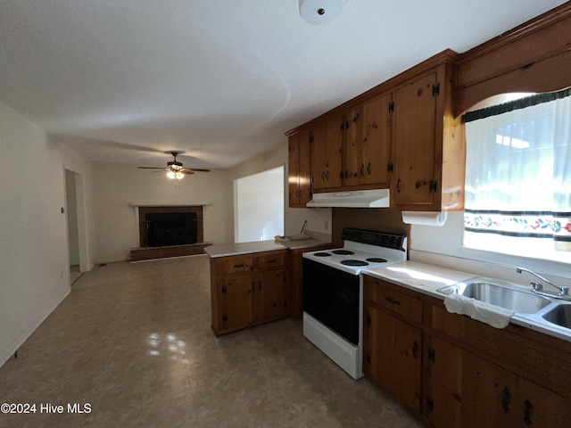 kitchen with kitchen peninsula, electric range, ceiling fan, and sink