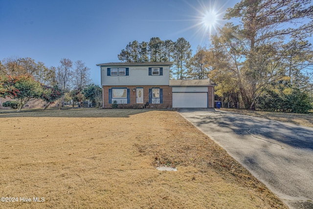 view of property featuring a front lawn and a garage