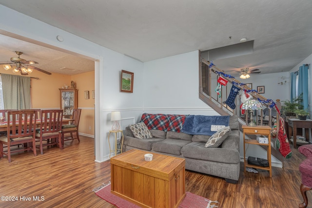 living room with hardwood / wood-style floors, a textured ceiling, and ceiling fan