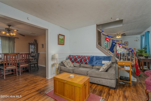 living room with ceiling fan, dark hardwood / wood-style flooring, and a textured ceiling