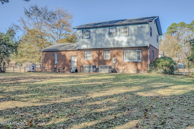 back of property featuring a yard and central air condition unit