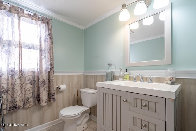 bathroom featuring vanity, crown molding, wooden walls, toilet, and a textured ceiling