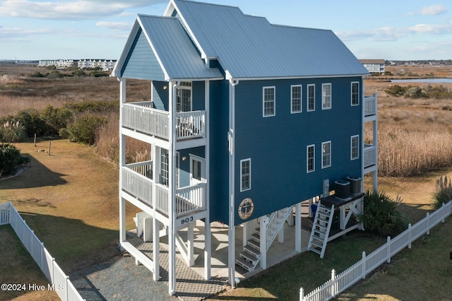 view of side of property with a lawn, a patio area, and a balcony