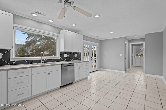 kitchen with stainless steel dishwasher, light tile patterned flooring, white cabinetry, and backsplash