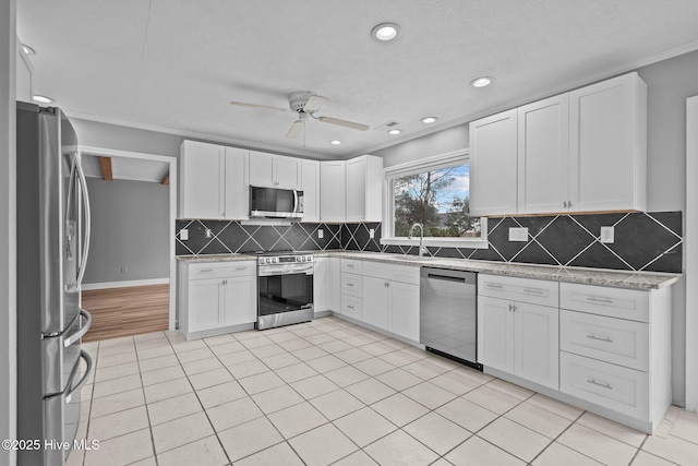 kitchen featuring stainless steel appliances, white cabinetry, and ceiling fan