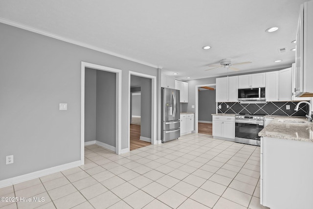 kitchen with ceiling fan, sink, stainless steel appliances, tasteful backsplash, and white cabinets